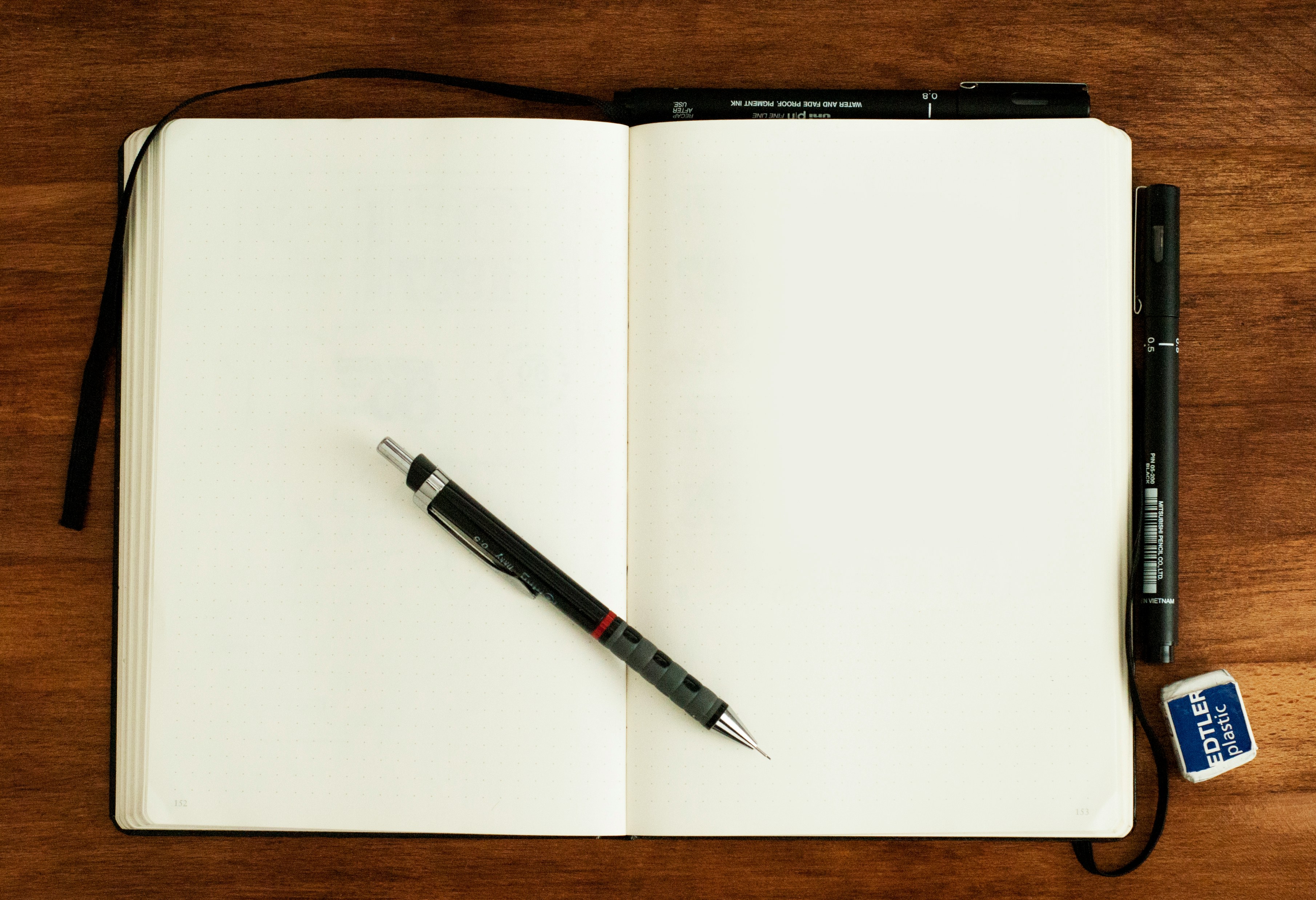 Open notebook and pencil on a wooden desk, ready for campaign planning