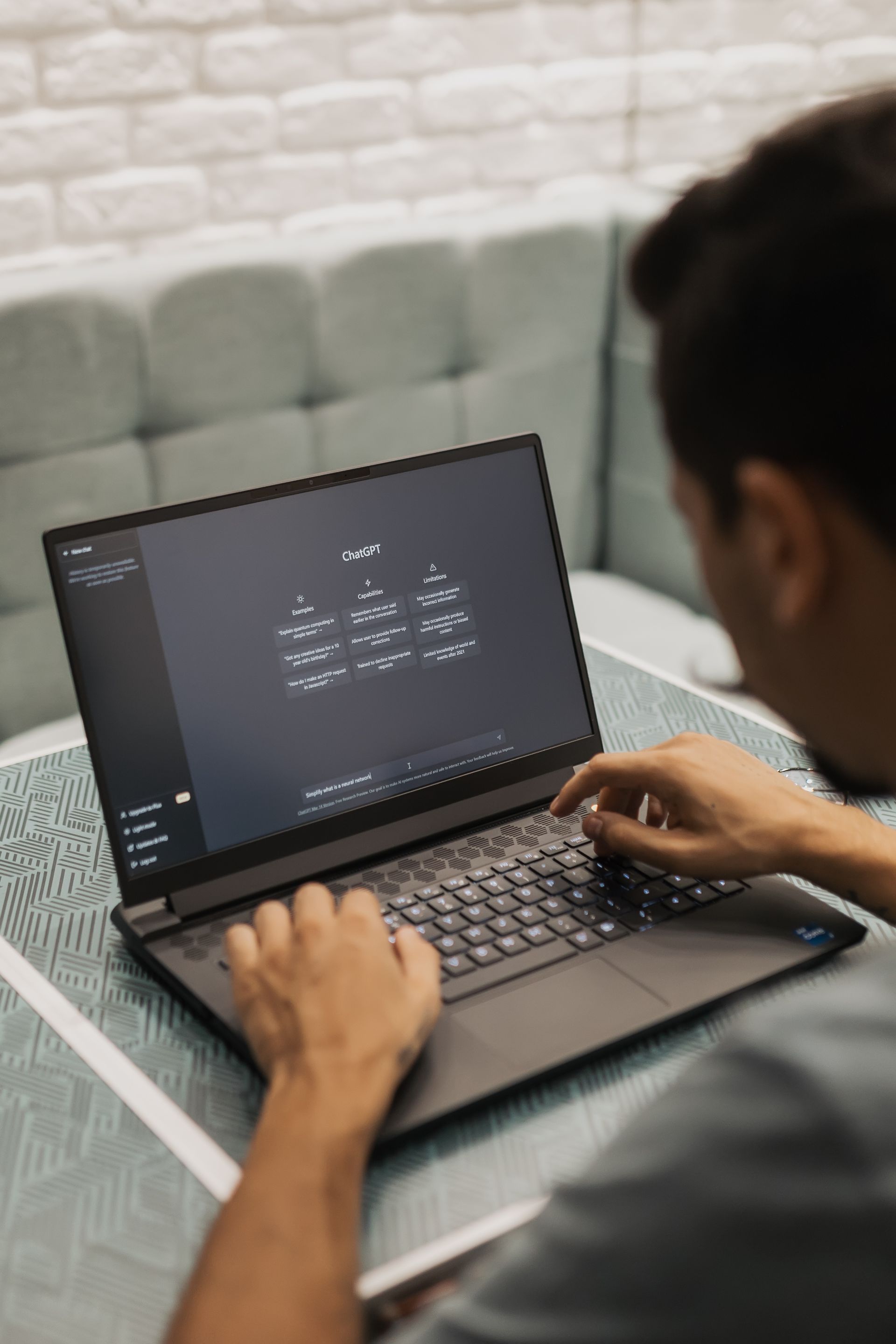 Man using ChatGPT on a laptop in a casual workspace