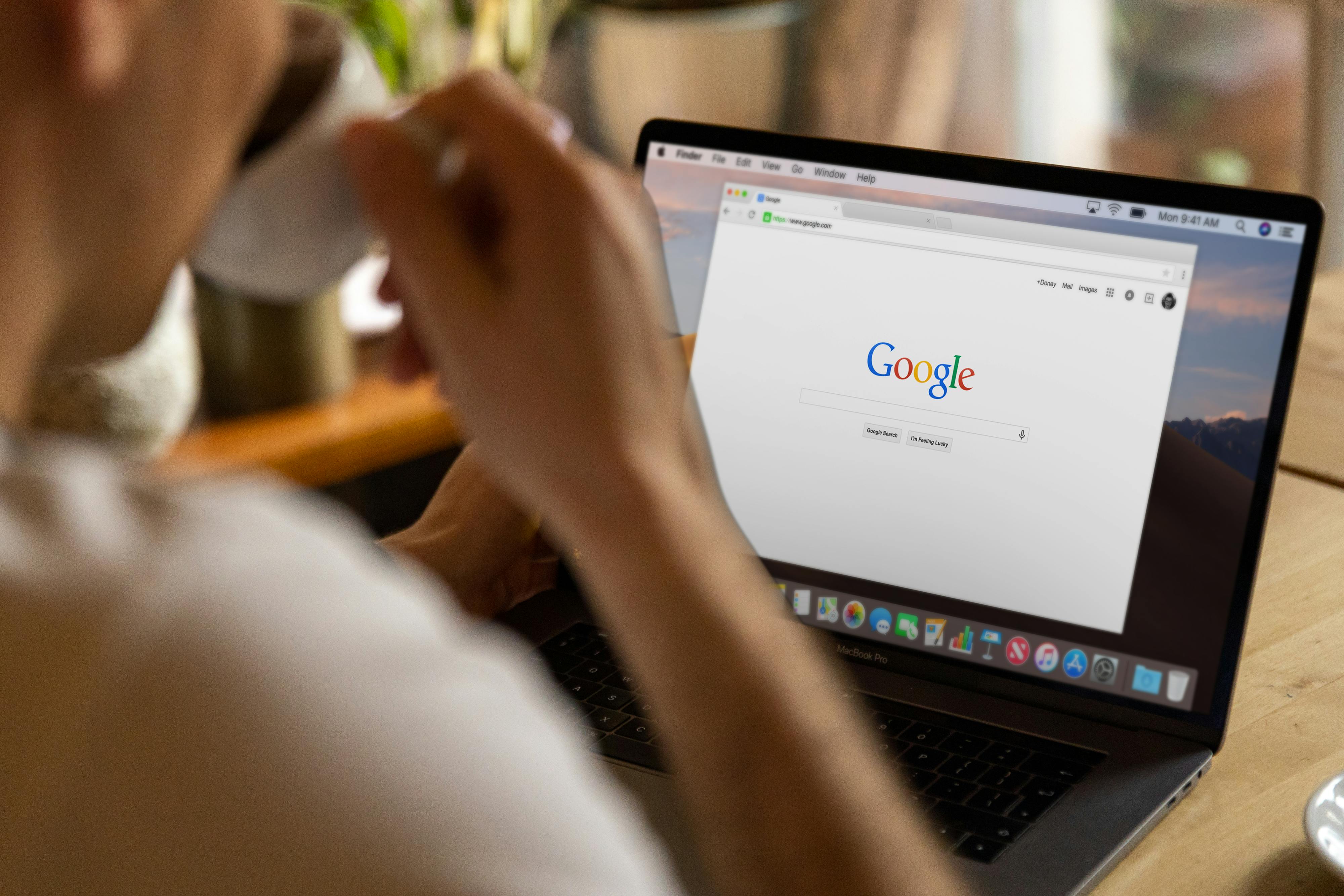 Person looking at the Google search homepage on a MacBook Pro