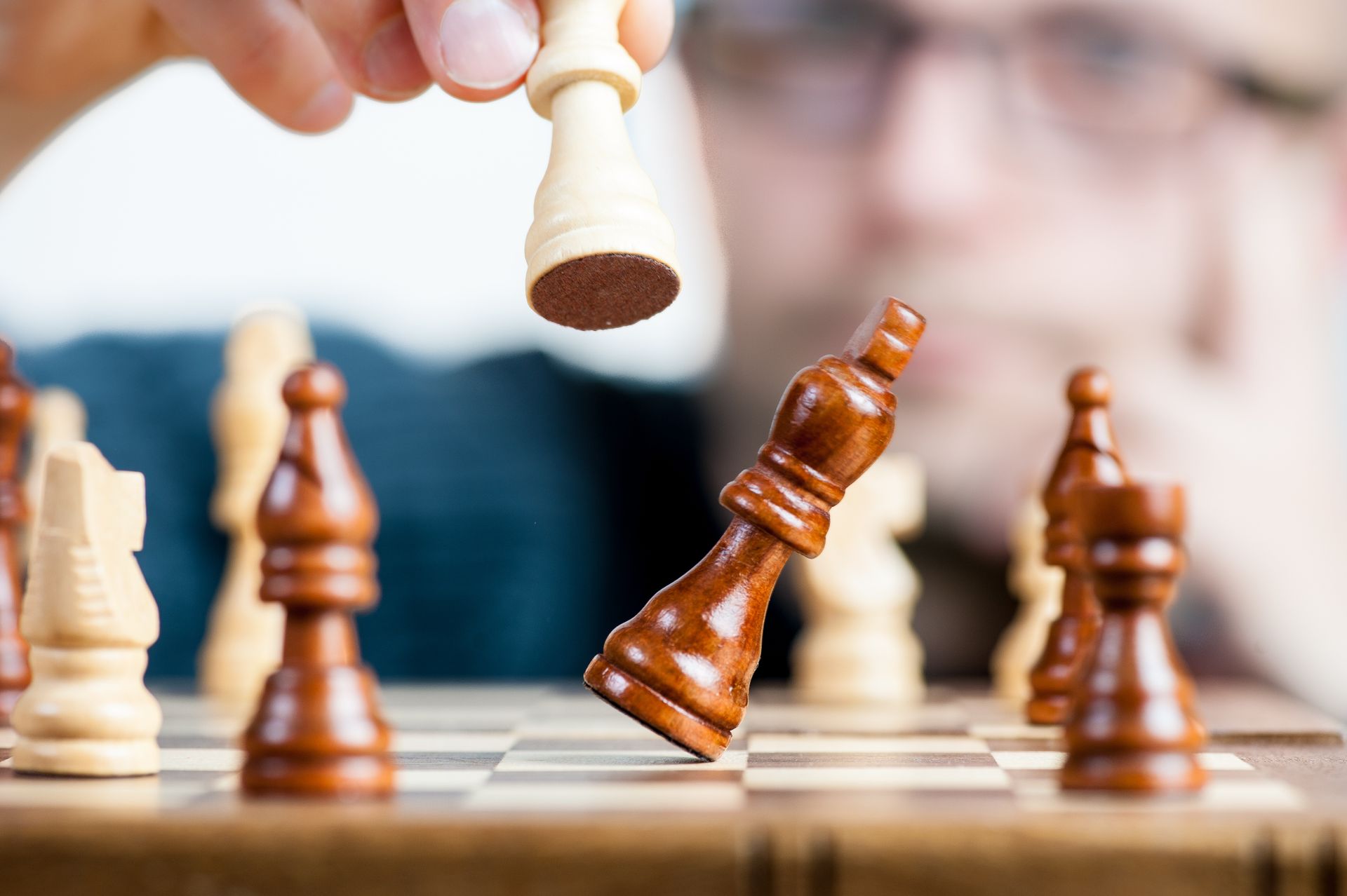 Man contemplating a move while holding a chess piece
