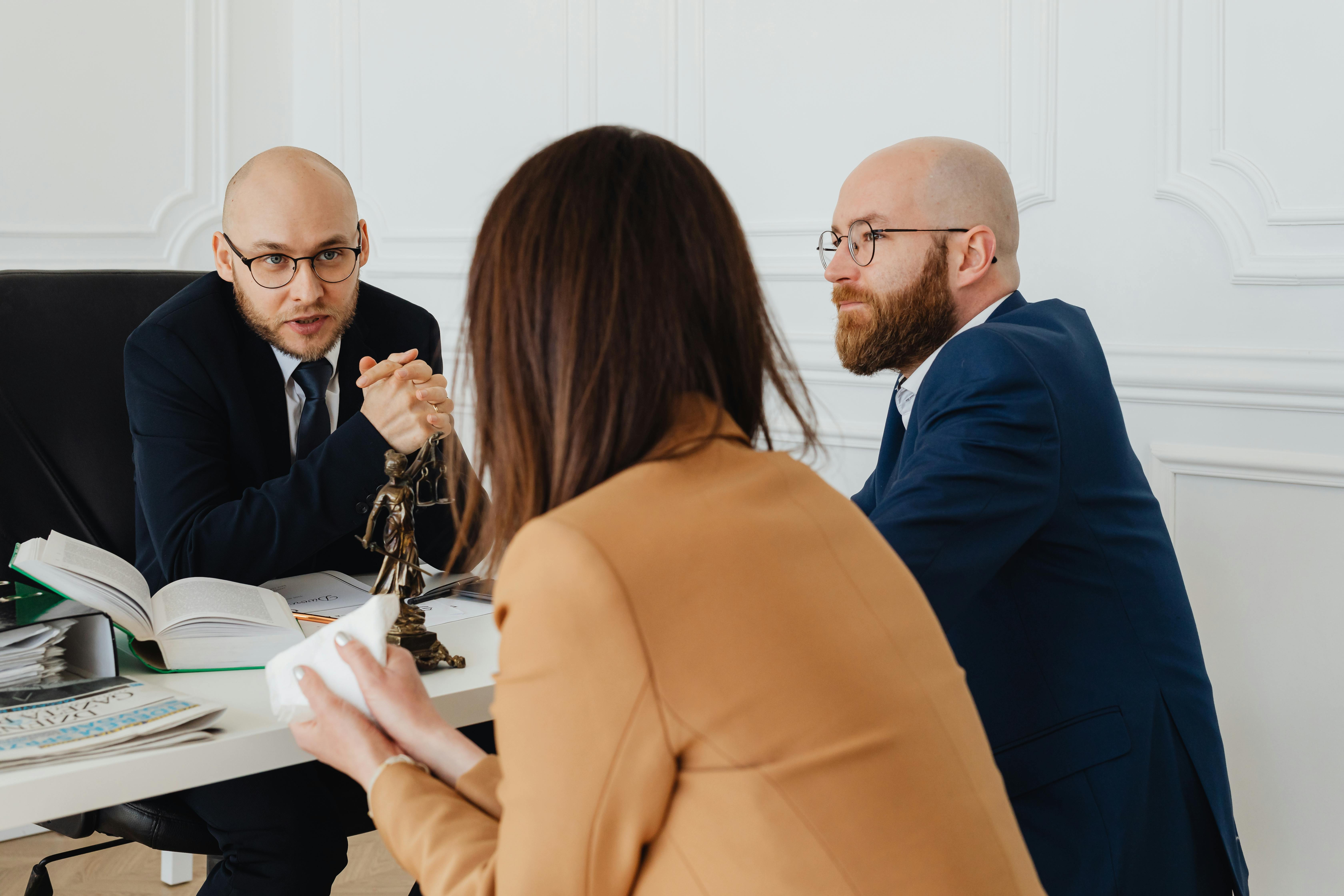 A consultation between an attorney and clients at a desk